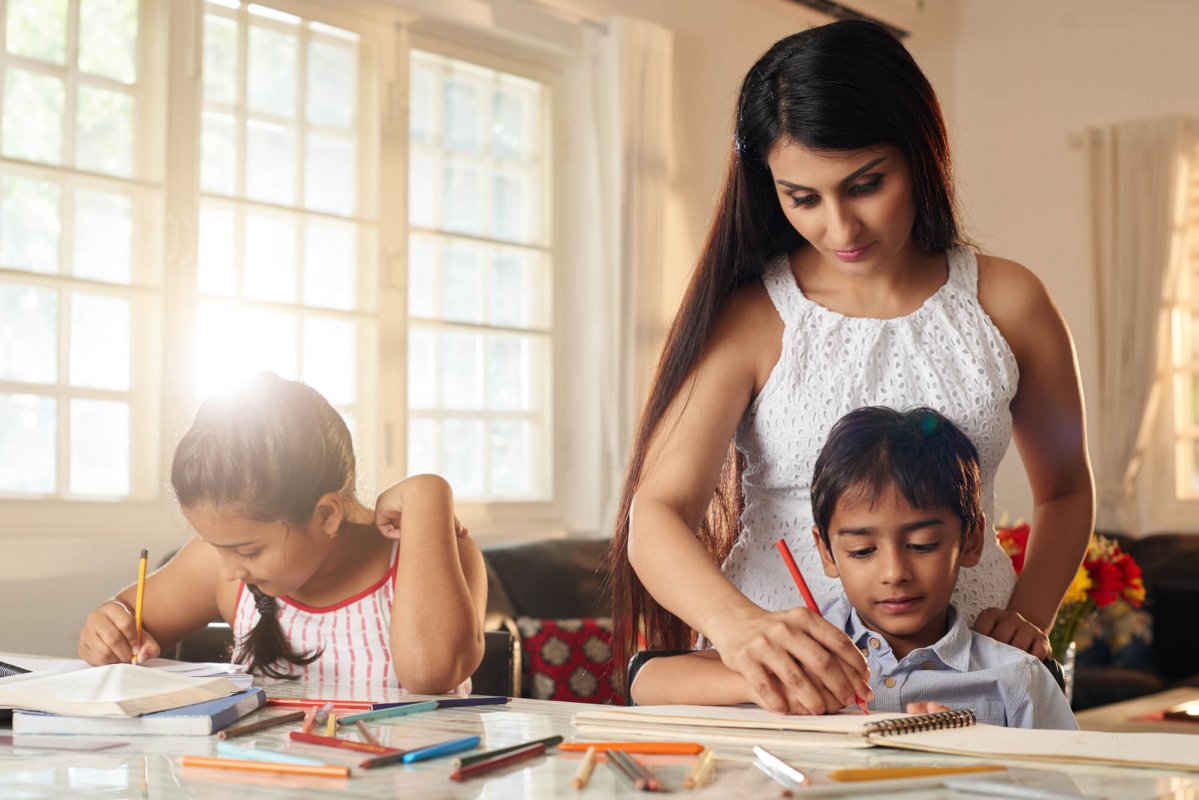 Como ajudar meu filho a estudar? Mãe ajudando nas tarefas de casa dos filhos
